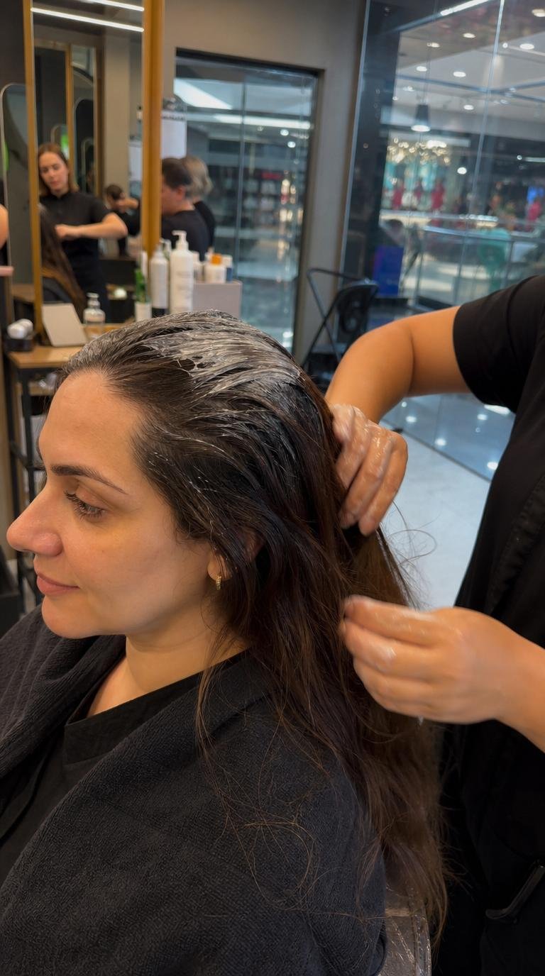 mulher em salão seguindo cronograma capilar para deixar os fios macios